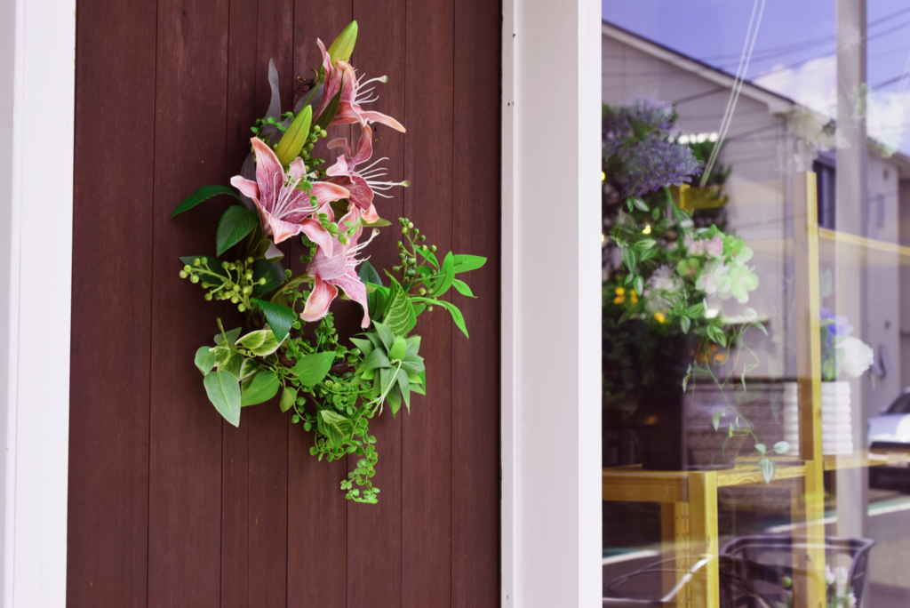 美容サロンのエントランスを飾る茶色のユリとグリーンのインテリアフラワーリース