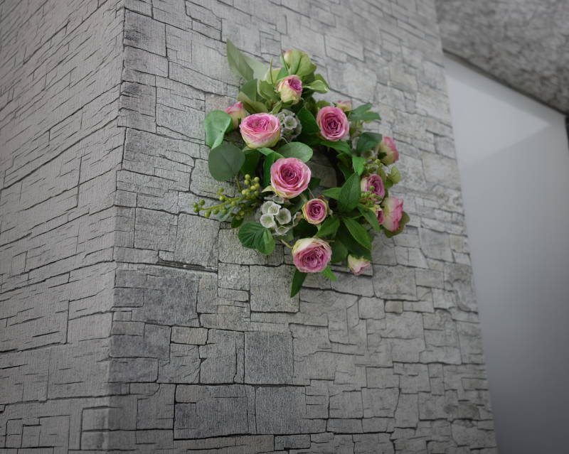 邸宅の廊下の壁に飾られた、アーティフィシャルフラワーでできたピンクの薔薇とたっぷりのグリーンのインテリアリース。